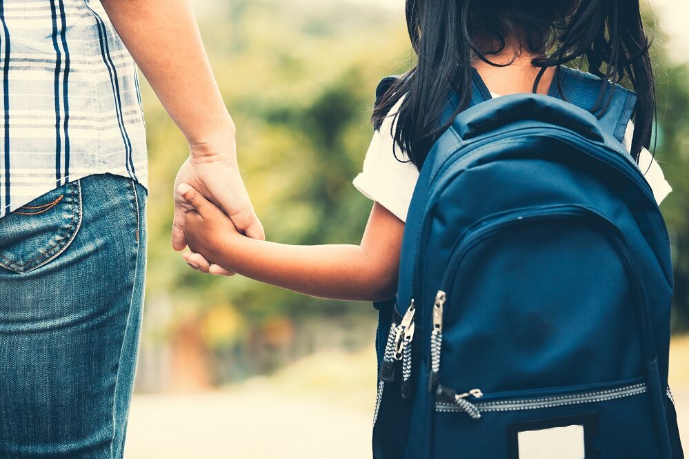 child with rucksack going to school